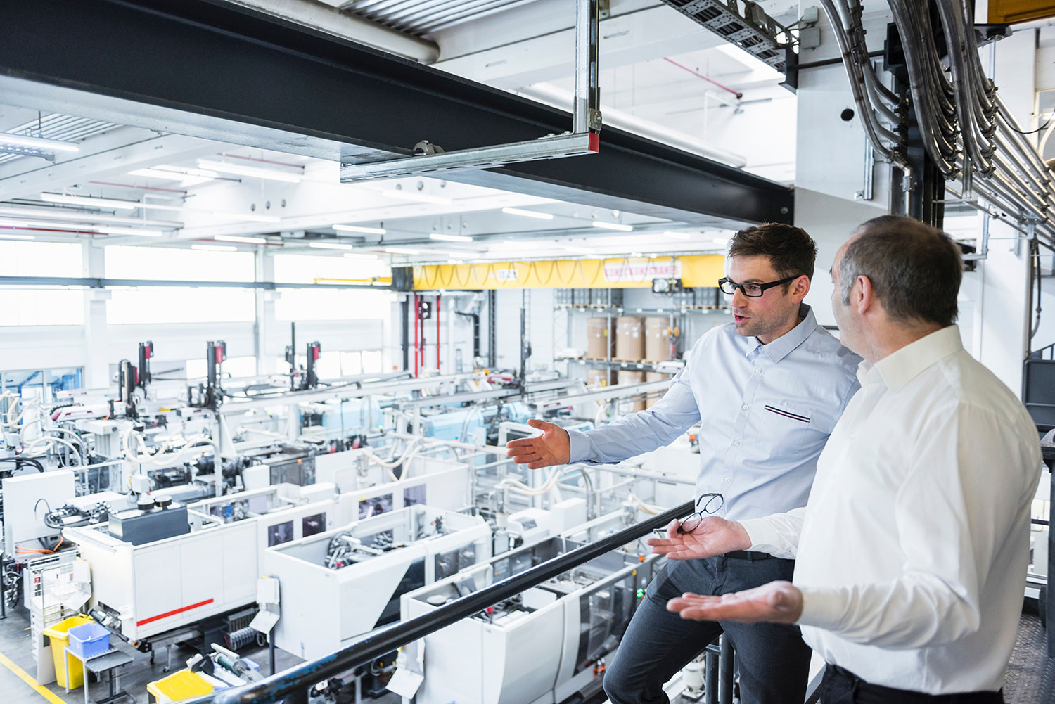 An image of people having a discussion with machinery in the background.