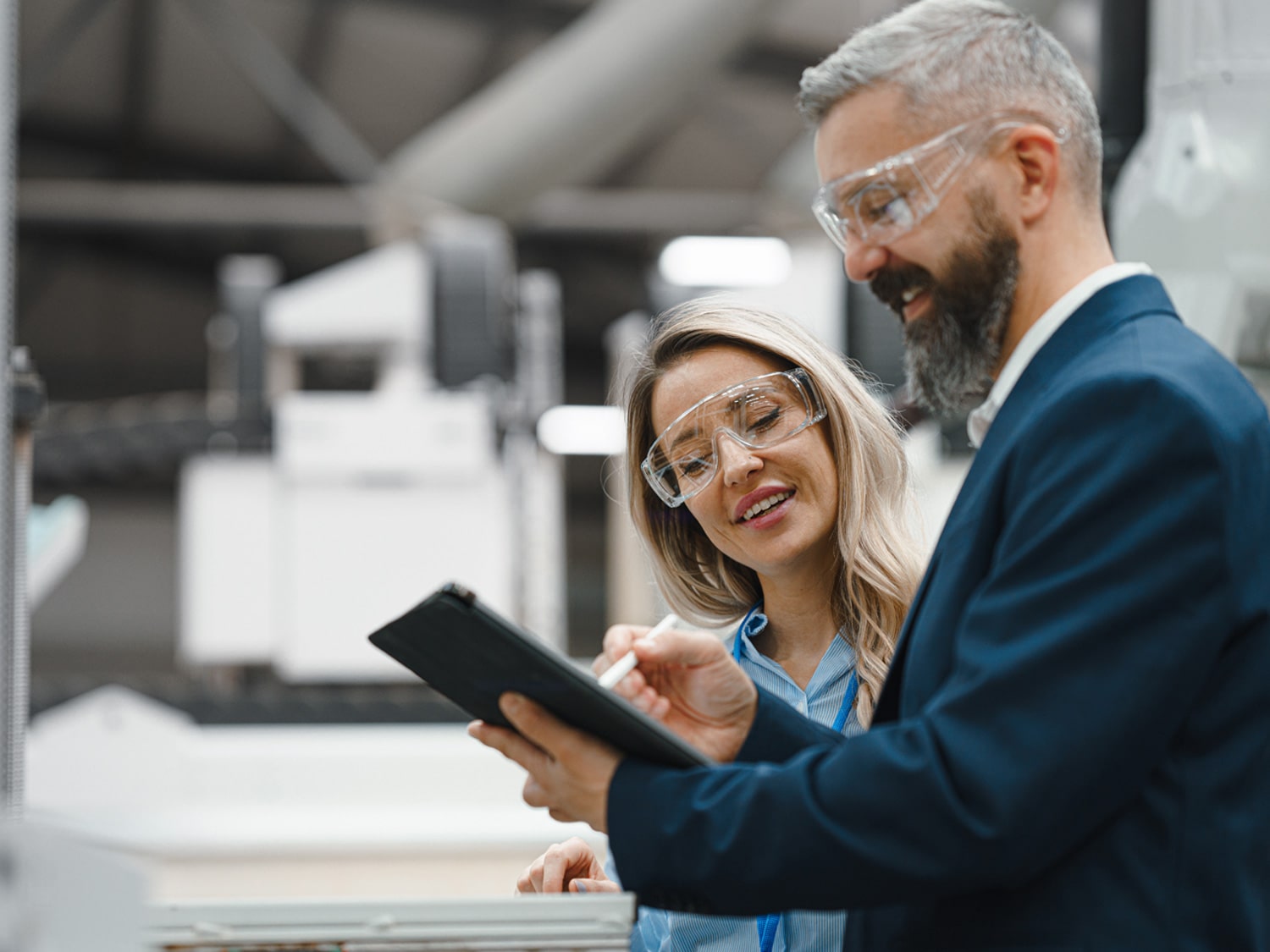 A man holding a tablet and pointing to it with a woman watching.