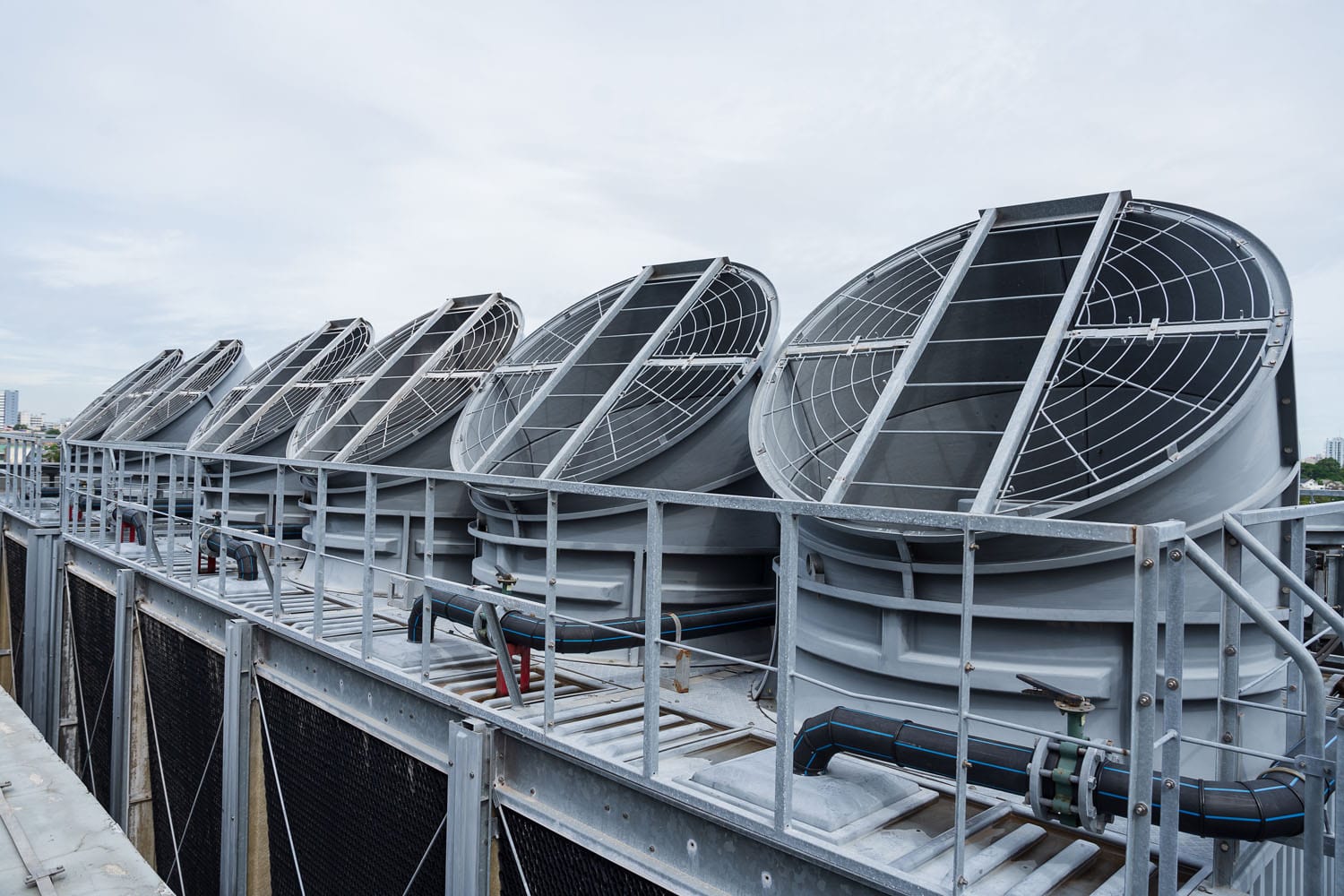 Large rooftop cooling fans and HVAC ventilation units on an industrial building.